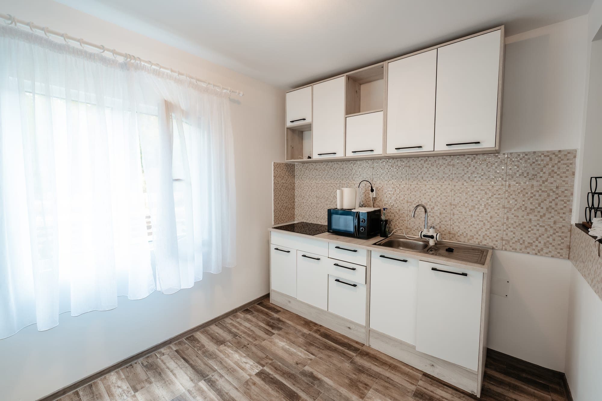 Bucătărie cu mobilier alb la Villa Palm